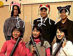 The three main voice actors, Juri Ihata, Kaori Shimizu, and Shitaya Noriko sit infront of three male members of the production team standing behind them wearing borg cosplay hats.