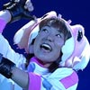 Kasumi's voice actor looks to the sky smiling whilst raising her hands in the air.