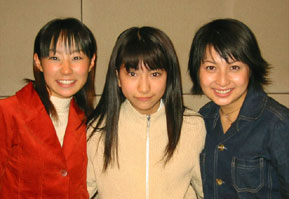 The three voice actors in casual clothing together and smiling.